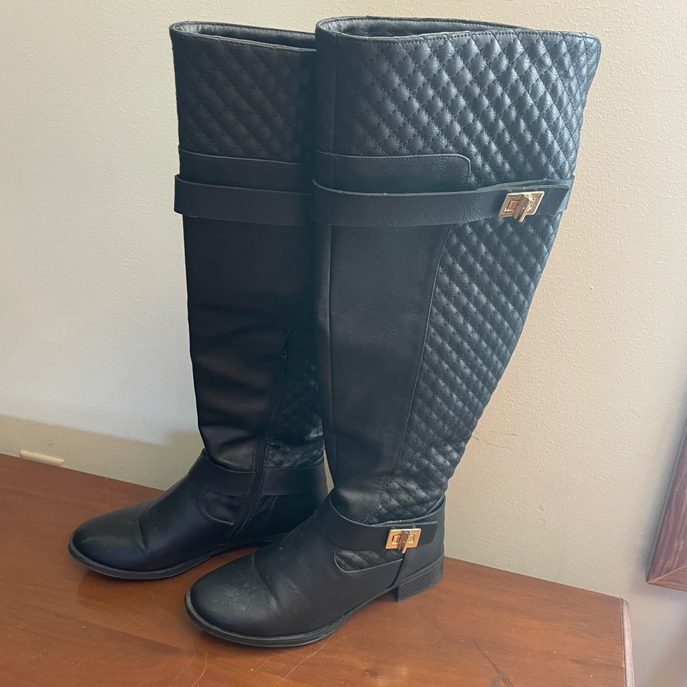 Quilted tall boot, decorative hardware, and zipper closure. 7.5 wide in black
